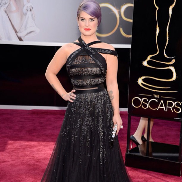 pink - haired woman in a black dress on the oscars red carpet