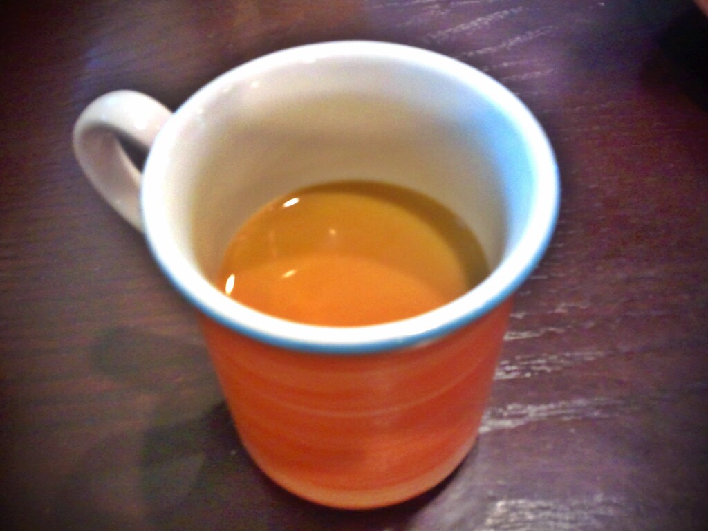 coffee is sitting in a orange mug