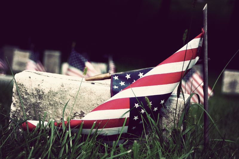 a patriotic, broken plane laying in the grass near graves