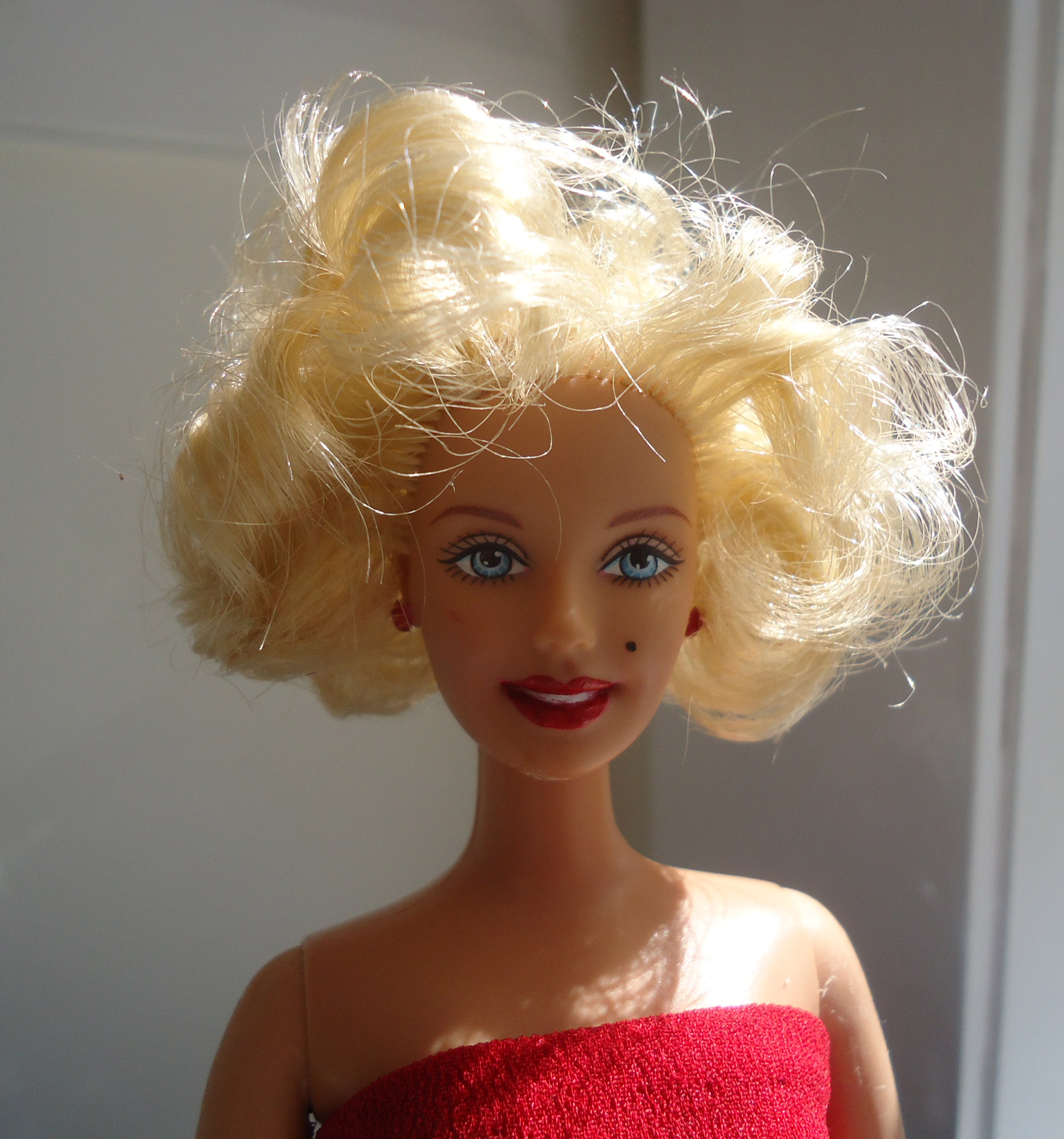 a doll with blonde hair in a red dress