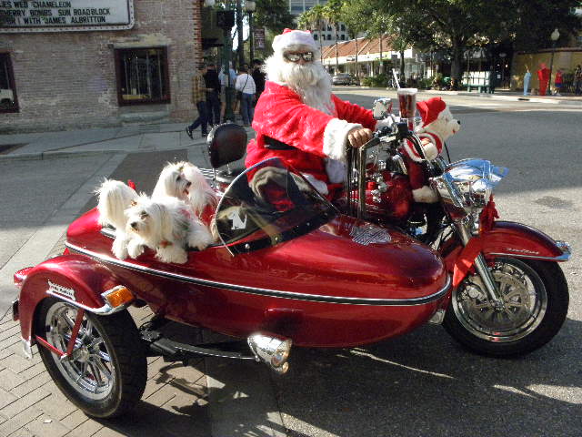 a santa clause riding on the back of a motorcycle