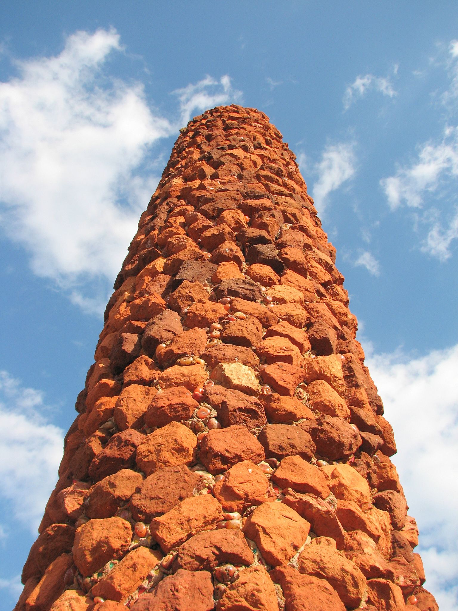 a red brick tower is near the blue sky