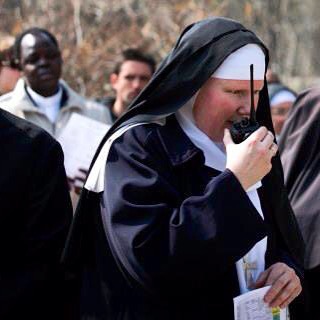 a woman dressed in a nun costume talking on a cellphone