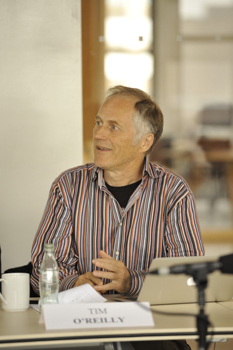 two men talking at a table with microphone