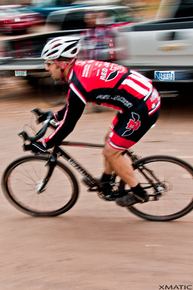 the man is riding his bike fast through the mud