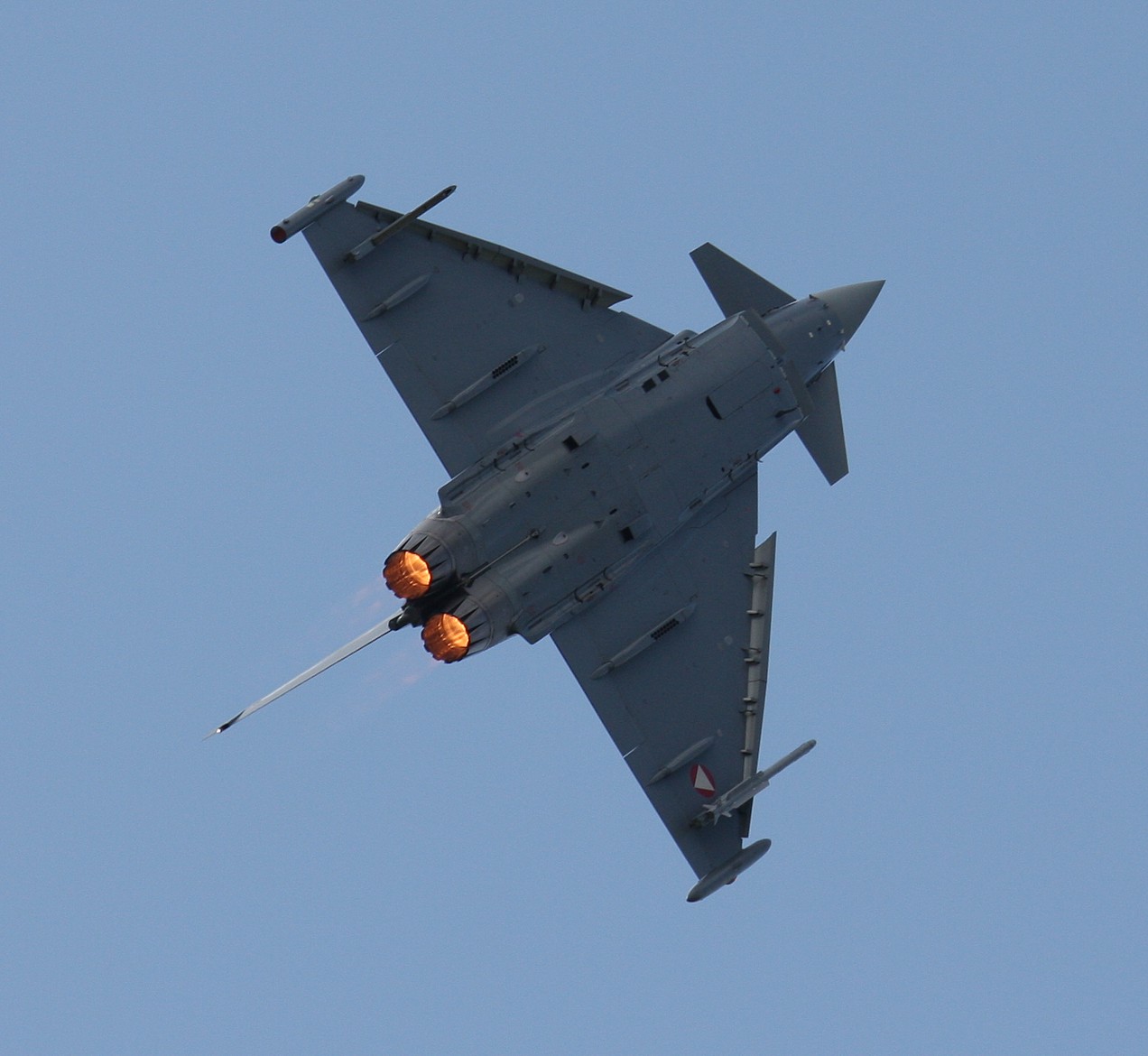 a fighter jet plane flying through the blue sky