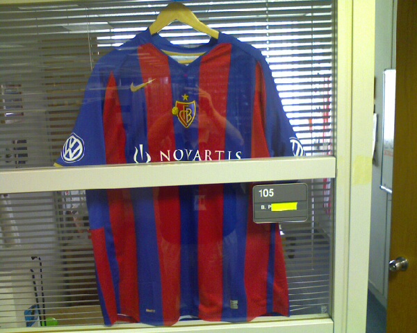 a small blue and red jersey is on display in a window