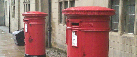 two red boxes are next to each other in front of a building