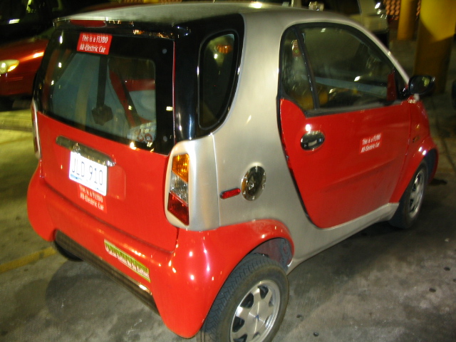 a small, electric car sits in a parking lot
