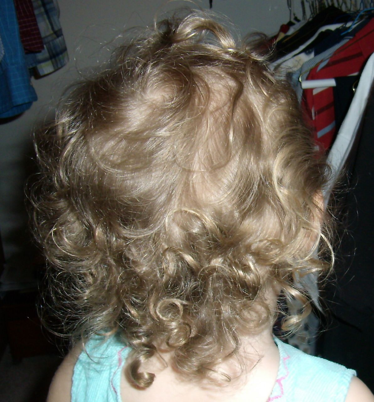 a little girl with blond hair is looking away