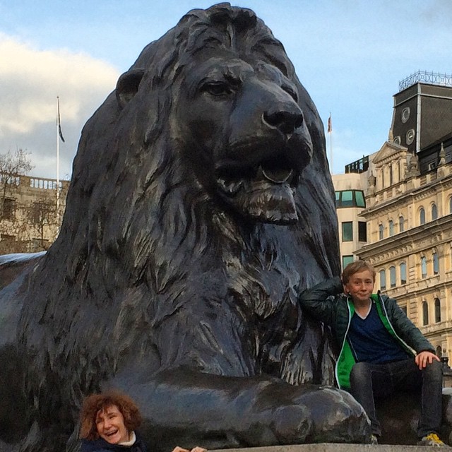 two s are standing next to a statue of a lion