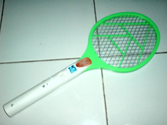 green and white badminton racket and ball on tile floor