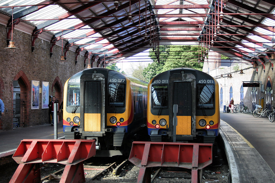 two commuter trains stopped at a train station