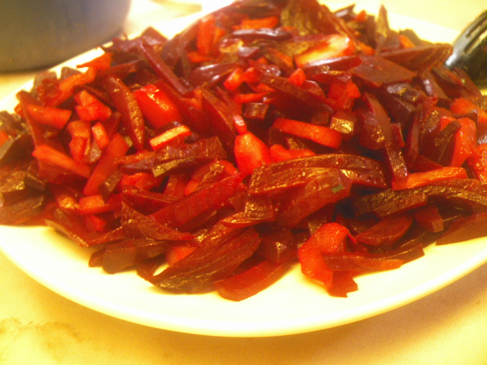 sliced and chopped red peppers sitting on a white plate