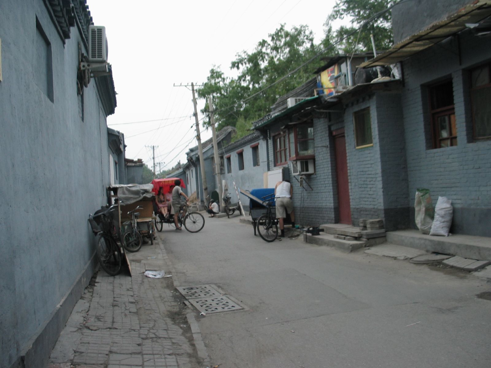 an alley in a neighborhood has many different bikes on the street