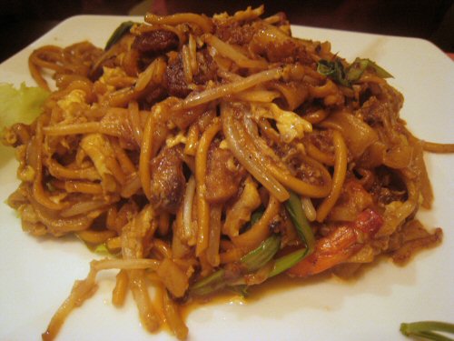 a plate of chinese noodles topped with meat