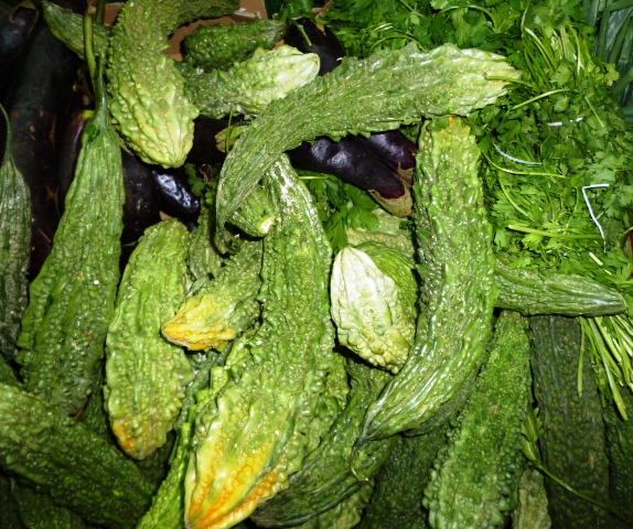 a pile of green cucumbers surrounded by some leaves