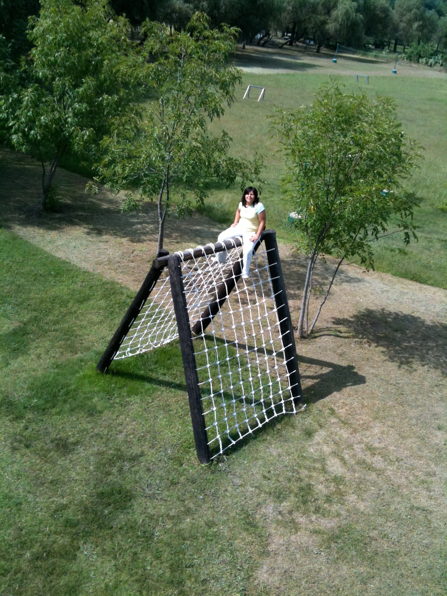 a young woman sits in a soccer net