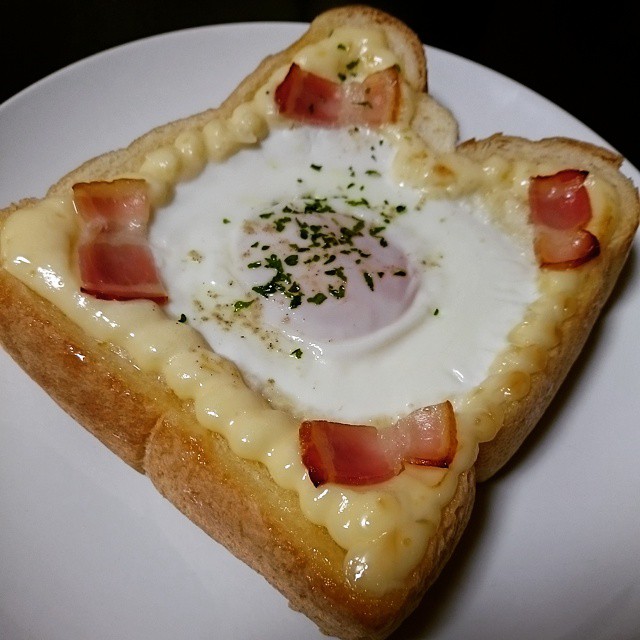 a slice of toast with an egg inside of it on a plate