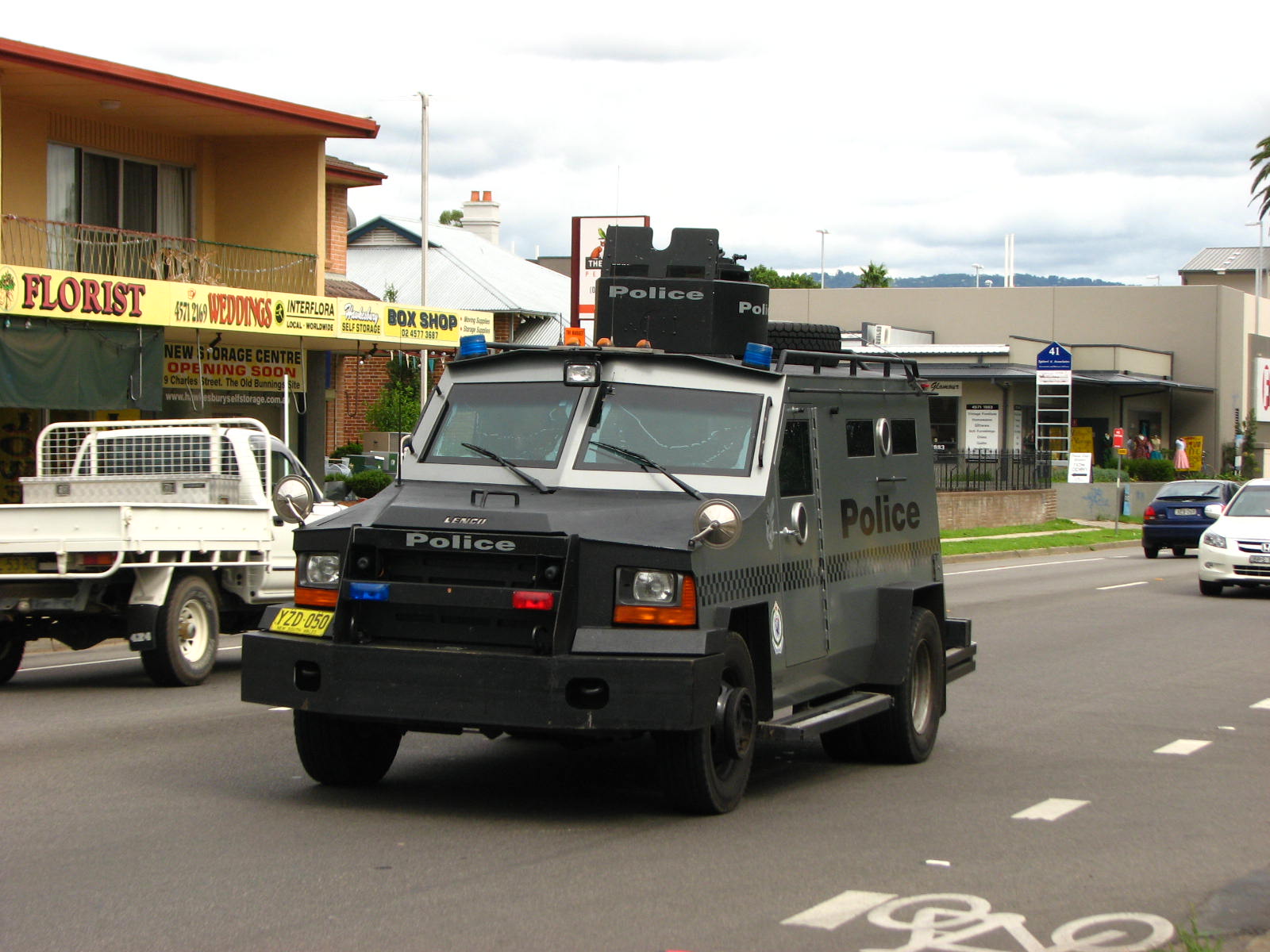 an armored police vehicle on a street near cars