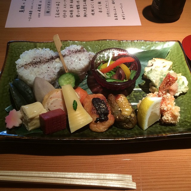 a plate with sushi and vegetables on it
