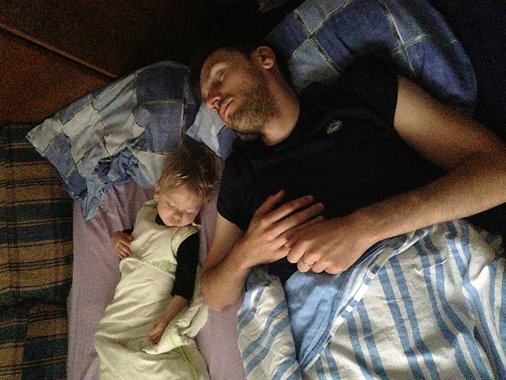 a man laying in bed with two babies