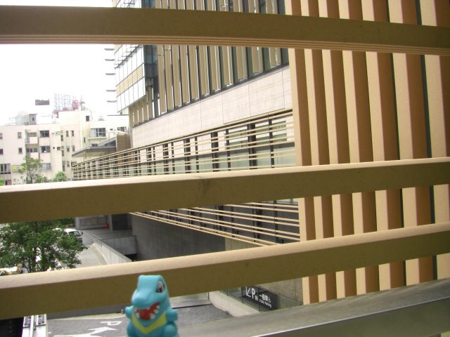 a toy sits in a window with an image of a city behind it