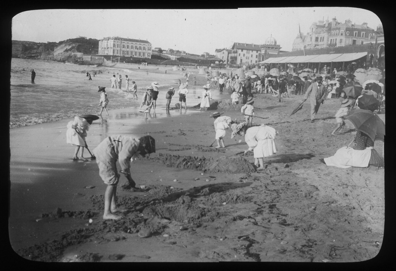 black and white pograph of people standing at a beach