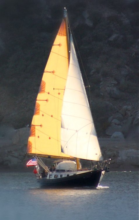 a sail boat in the water with an american flag on it
