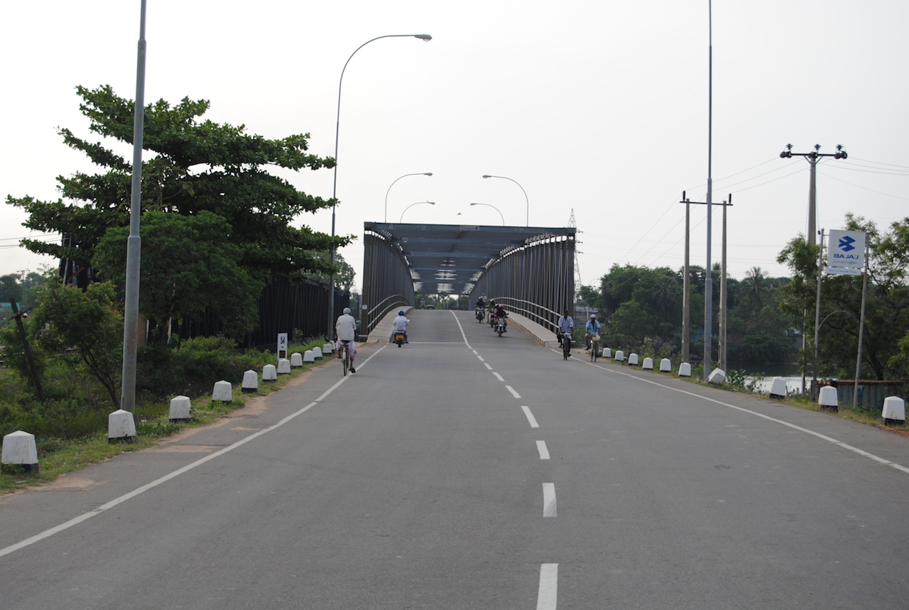two people riding bikes on a large bridge