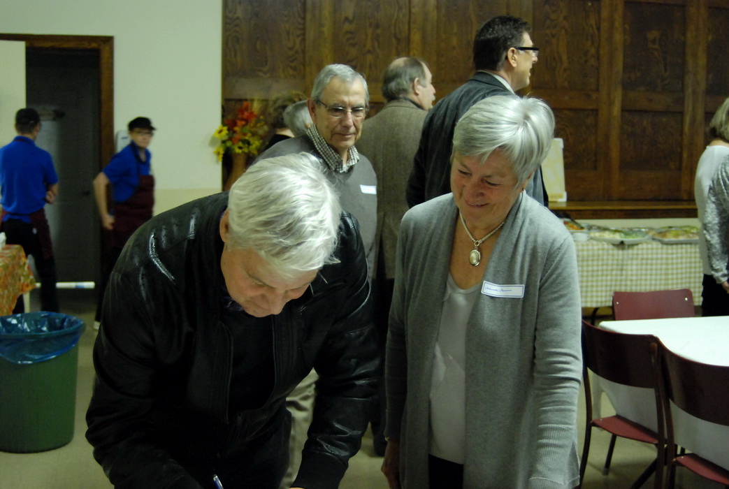 two elderly women are looking at a cake together