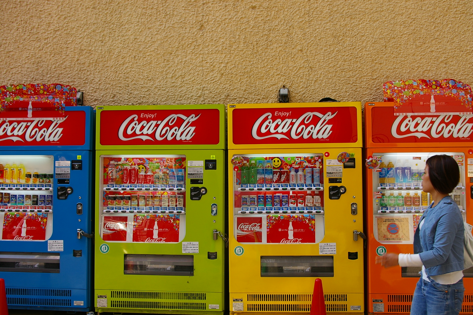 two woman are talking by a vending machine