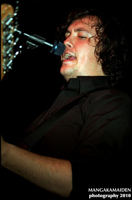 a man on stage holding his face up with a microphone