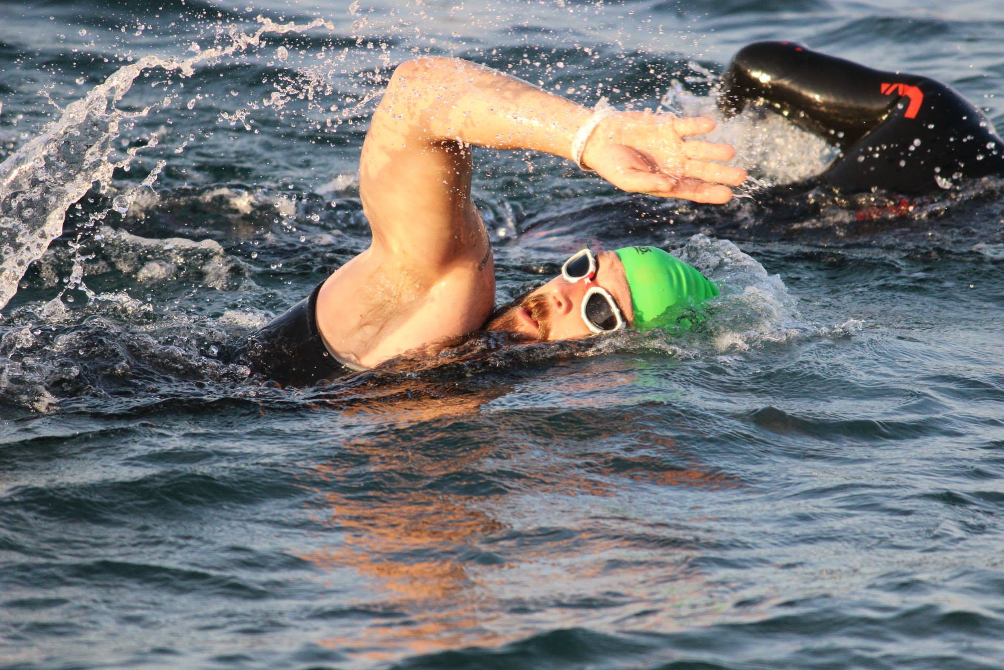 a man in goggles swimming through the water