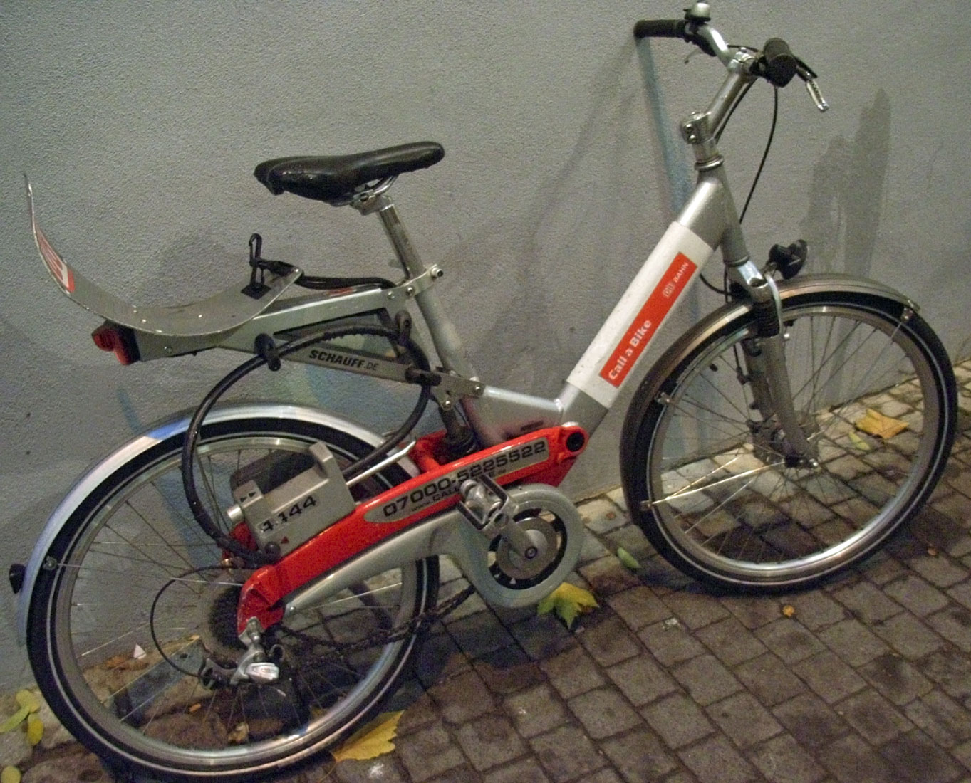 a bicycle is parked next to a grey wall