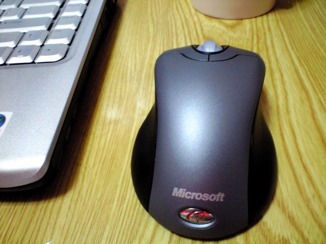 a mouse and keyboard on a desk next to a laptop