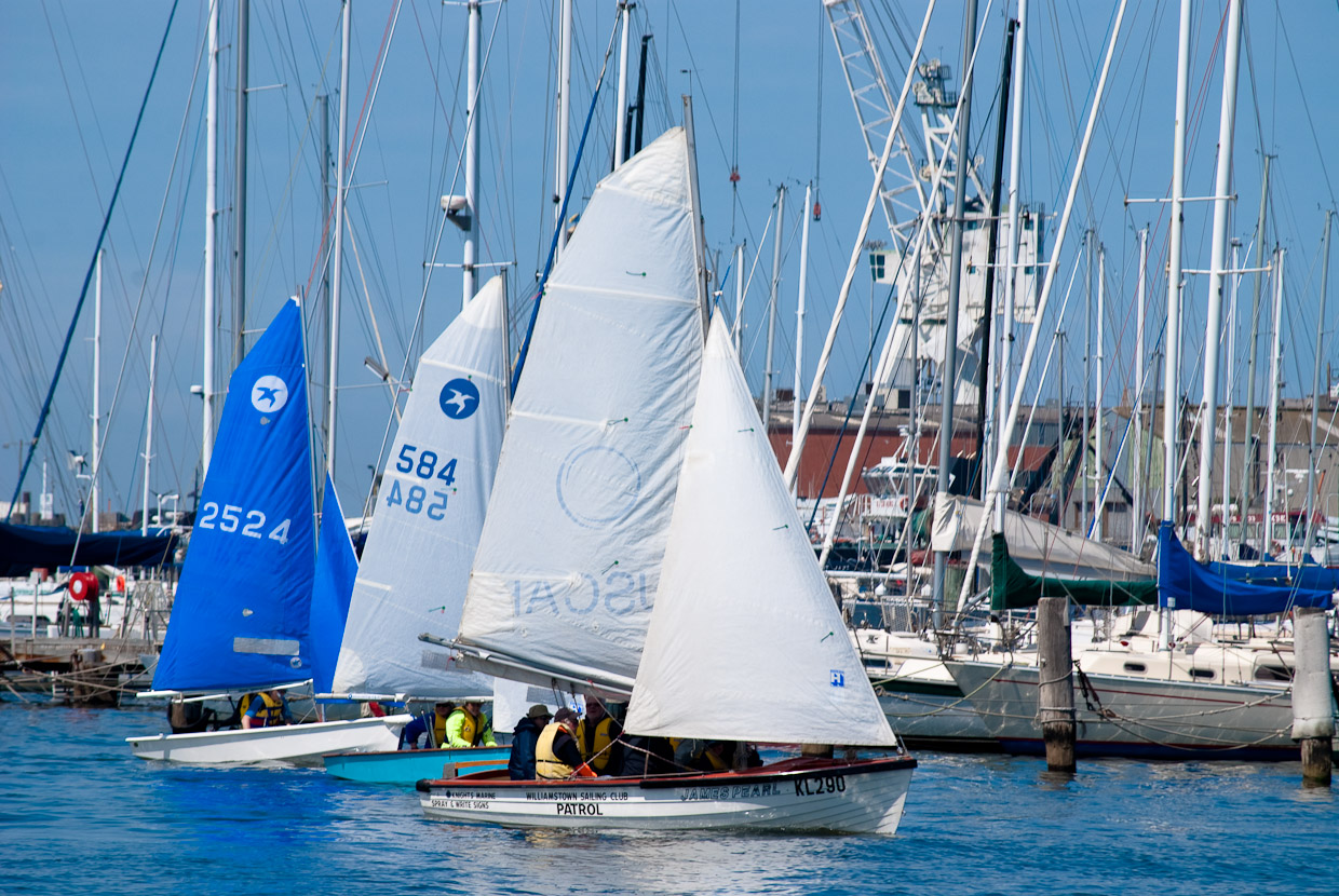 several small boats are sitting on the water in the marina