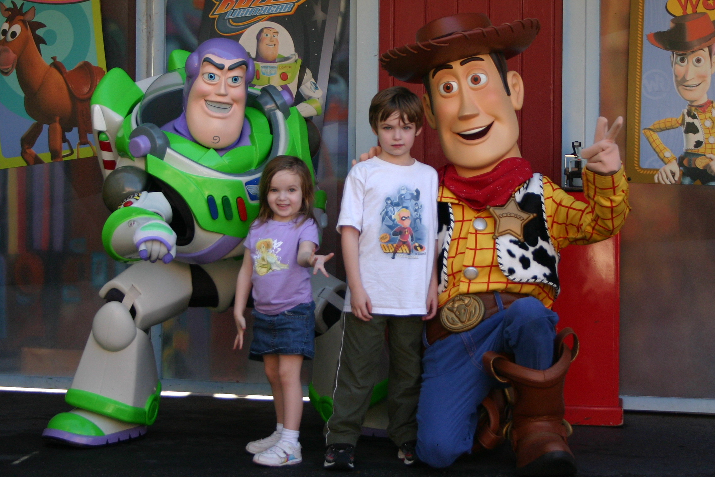 children pose for a picture in front of characters from the toy story