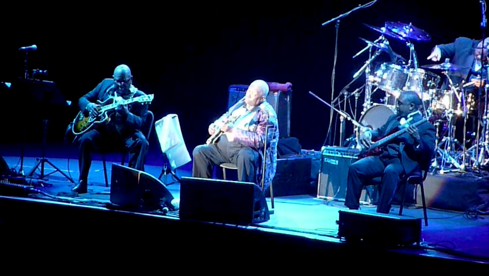 a band playing on stage with guitars and keyboard