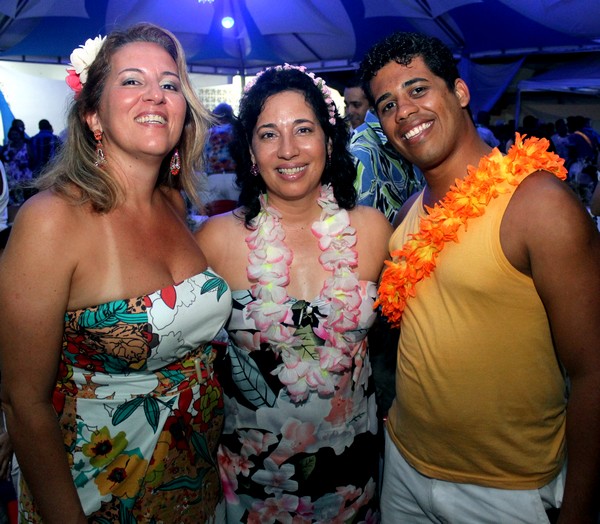 three ladies, one in a lei and the other in a colorful dress