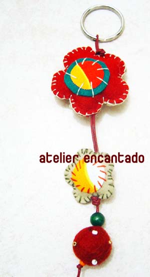 a key chain made with fabric material featuring an image of a red flower