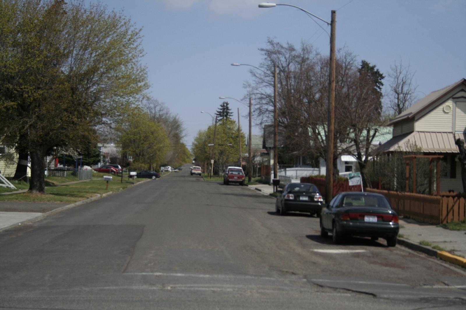 the street is deserted and some cars are driving on it