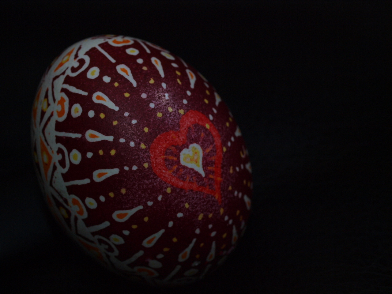 a red painted egg sitting on top of a black surface