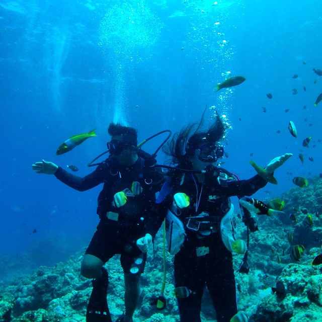 two scuba divers posing for po on a reef