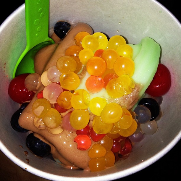a bowl of assorted jelly beans with a plastic green pickle in it