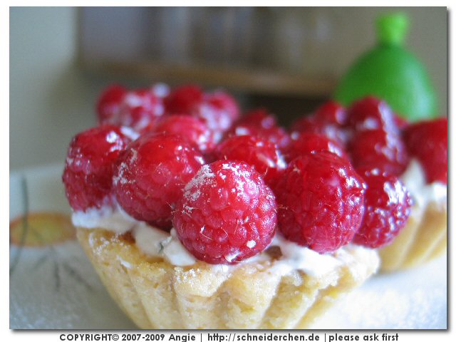 a pastry with many raspberries is decorated on the top