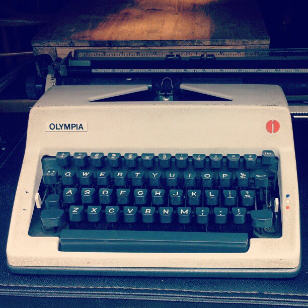 an old typewriter sitting next to a small machine