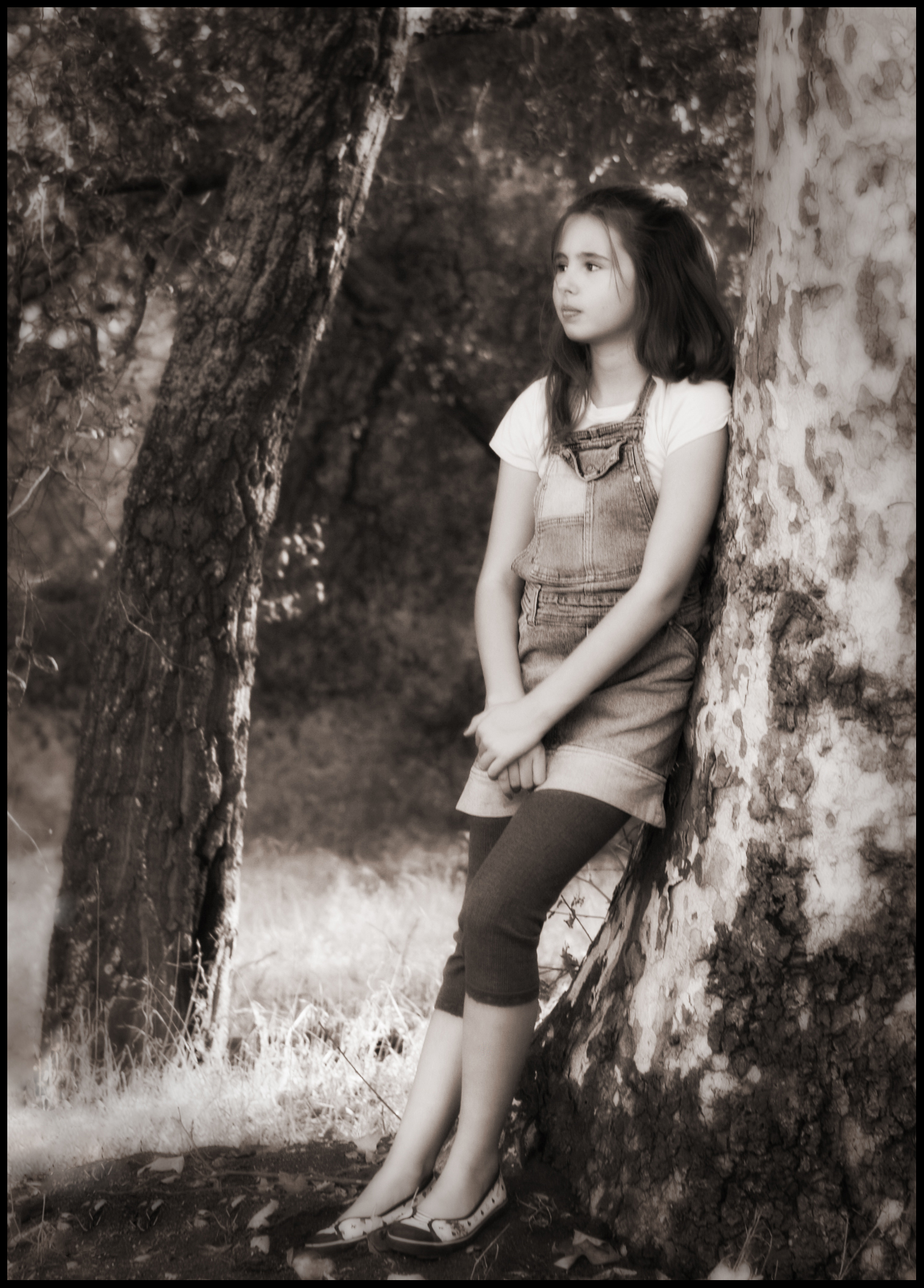 young woman leaning on tree, in black and white po