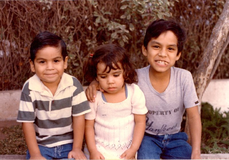 three children sitting next to each other with a smile
