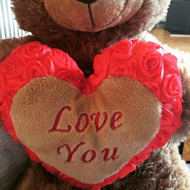 a teddy bear with roses in the shape of a heart